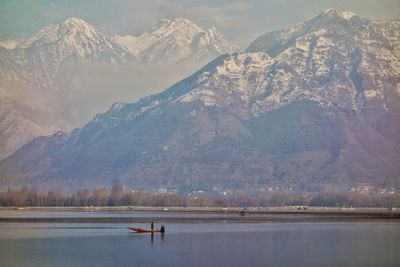 Scenic view of lake by snowcapped mountains