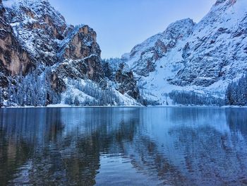 Scenic view of lake by snowcapped mountains against sky