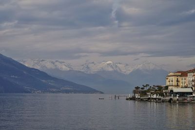 Scenic view of sea by city against sky and mountains