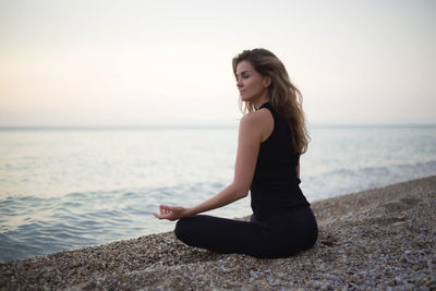 Woman meditating on beach