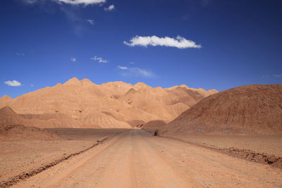 Scenic view of desert against blue sky