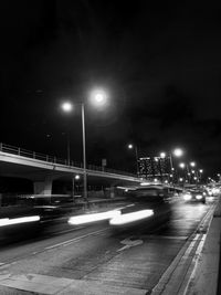 Cars on illuminated street at night
