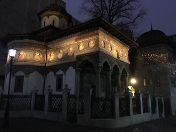 Illuminated buildings against sky at night