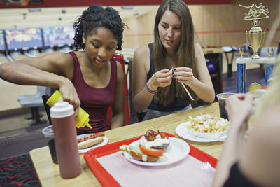 Young women eating at a diner together.