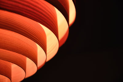 Close-up of illuminated lamp shade against black background