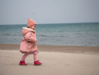 Low section of woman standing at beach