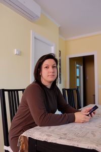 Portrait of woman sitting at home