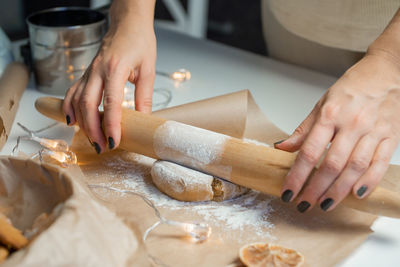 Roll out the gingerbread dough in flour on parchment with a garland with a rolling pin