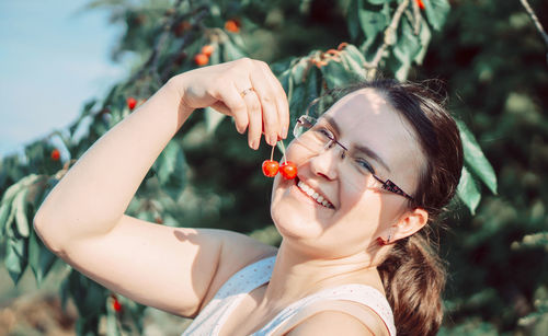 Portrait of young woman holding fruits