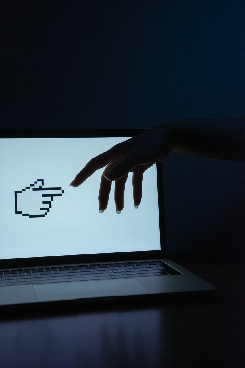 LOW ANGLE VIEW OF PERSON HAND USING LAPTOP