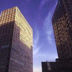 Low angle view of modern building against blue sky