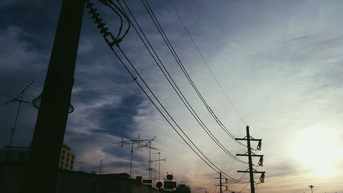 Low angle view of silhouette electricity pylon against sky