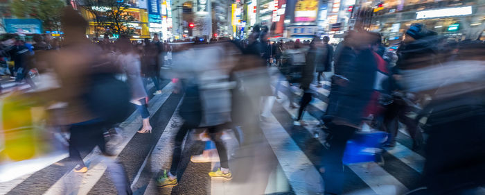 Group of people walking in illuminated city