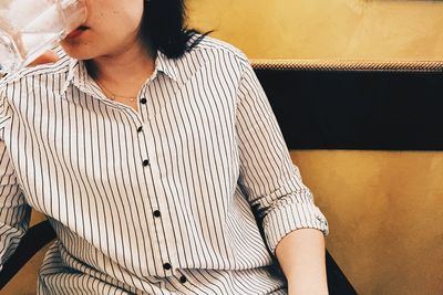 Close-up mid section of a woman drinking water