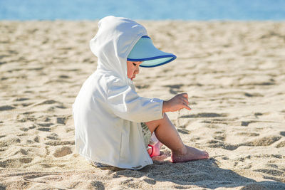 Rear view of woman standing at beach