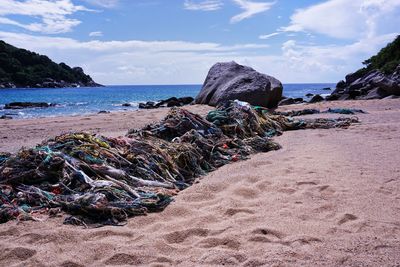 Scenic view of rocks on beach against sky