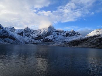 Scenic view of lake and snowcapped mountains against sky