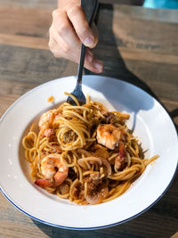 Midsection of person having food in plate on table