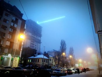 City street amidst buildings against sky at dusk