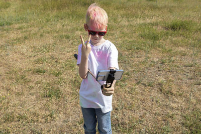 Caucasian boy takes selfie. photo, child with colorful dye at birthday party or celebrating holi