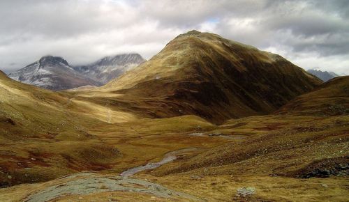 Scenic view of mountains against cloudy sky