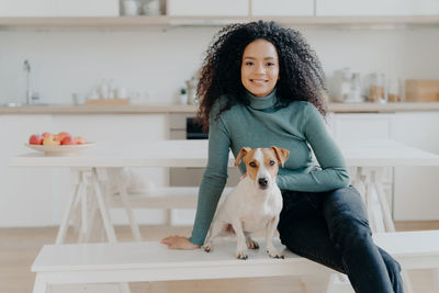 Woman with dog sitting at home