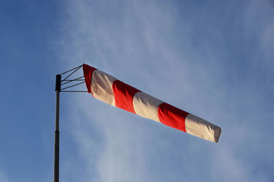 Wind cone weather vane on windy day with blue sky in the background.