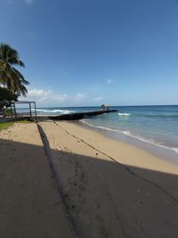 Scenic view of beach against blue sky