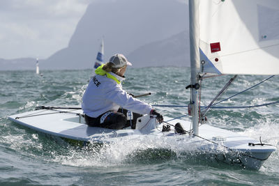 Woman on boat sailing in sea against sky