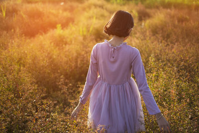 Rear view of woman standing on field