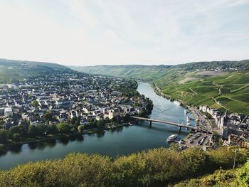 Scenic view of river by buildings against sky