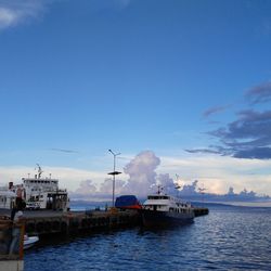 Boats in harbor against sky