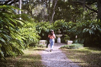 Full length rear view of girl standing on footpath