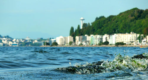 Waves flowing at sea with space needle in background
