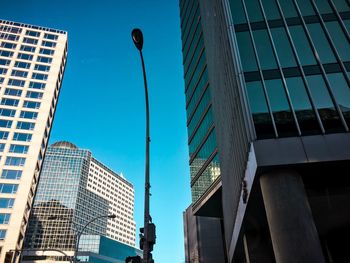 Low angle view of modern buildings against blue sky