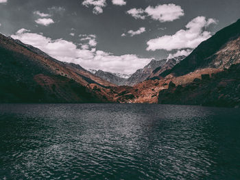 Scenic view of lake by mountains against sky