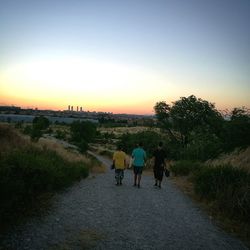 People walking on road at sunset