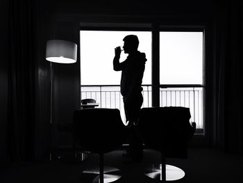 Rear view of woman sitting on wall