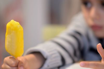 Close-up of boy holding mango ice pop