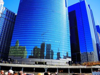 Low angle view of skyscrapers against blue sky