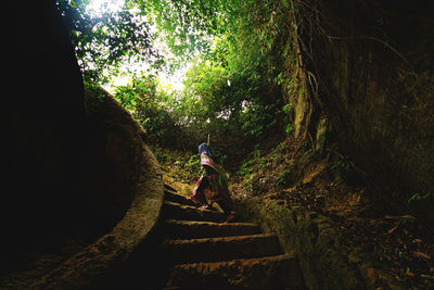 Boy amidst trees in forest