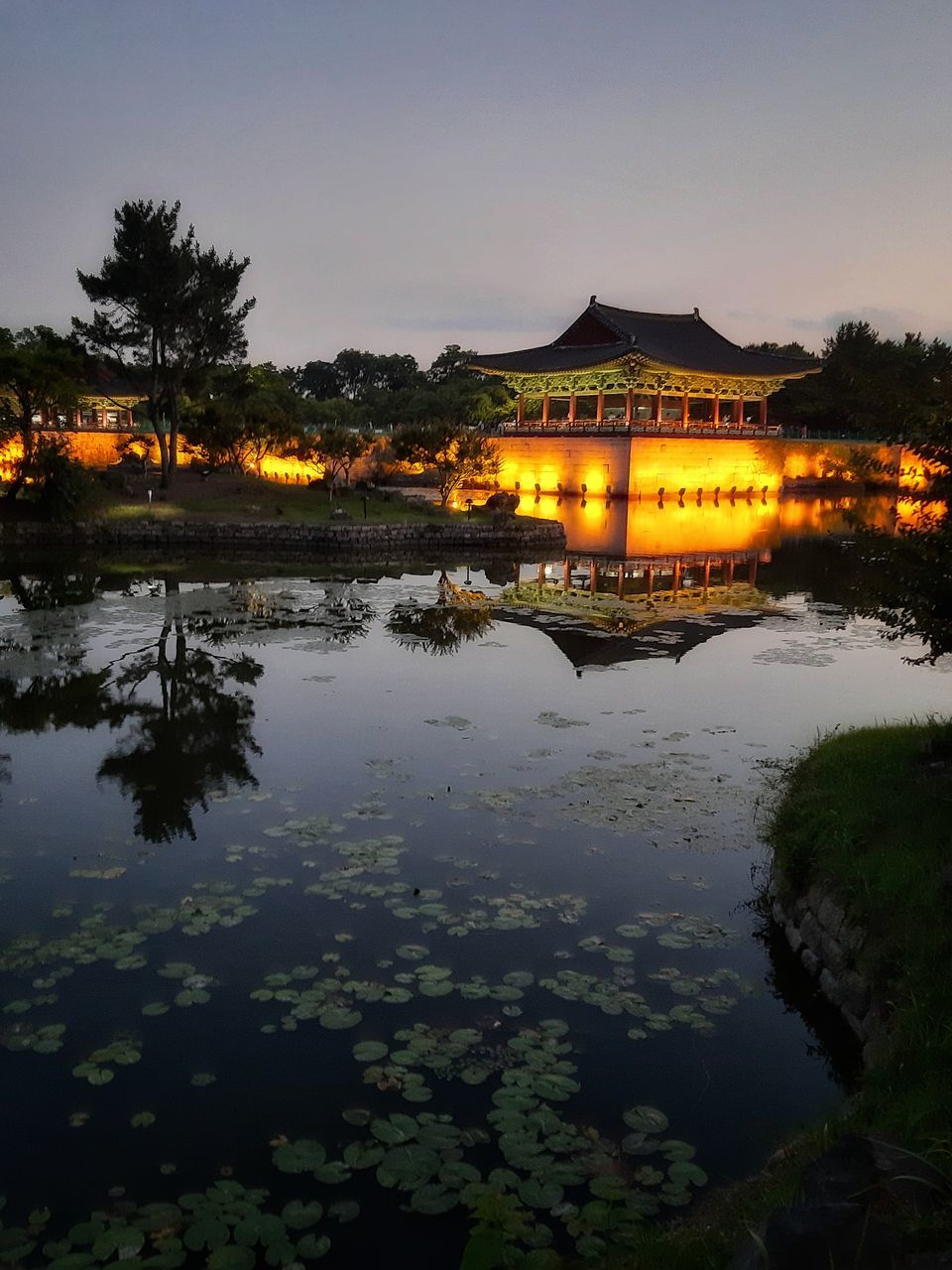 REFLECTION OF ILLUMINATED BUILDING IN LAKE