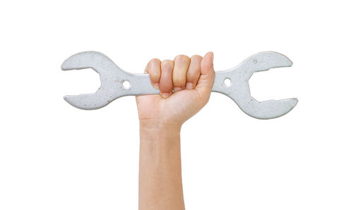 Close-up of hand holding paper over white background