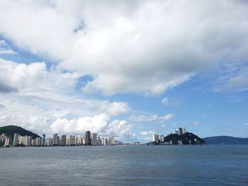 Scenic view of sea by buildings against sky