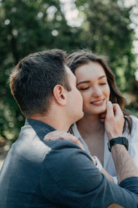 Close-up of young man kissing on girlfriend cheek in park