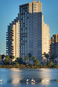 Sea by buildings against sky in city