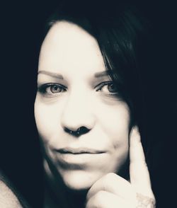 Close-up portrait of beautiful young woman over black background