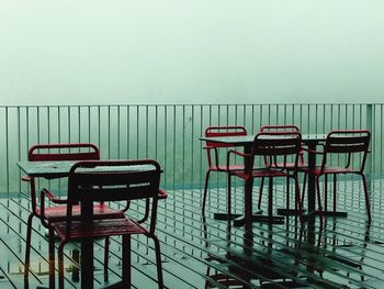 Empty chairs and table against clear sky