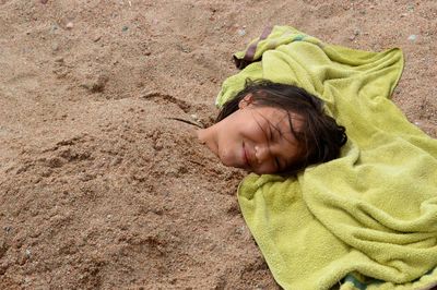 Close-up of girl buried in sand