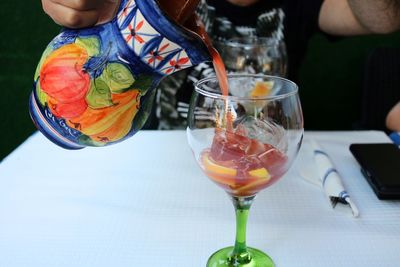 Close-up of man holding drink on table